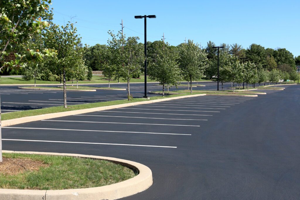 An empty, paved parking lot in the middle of summer