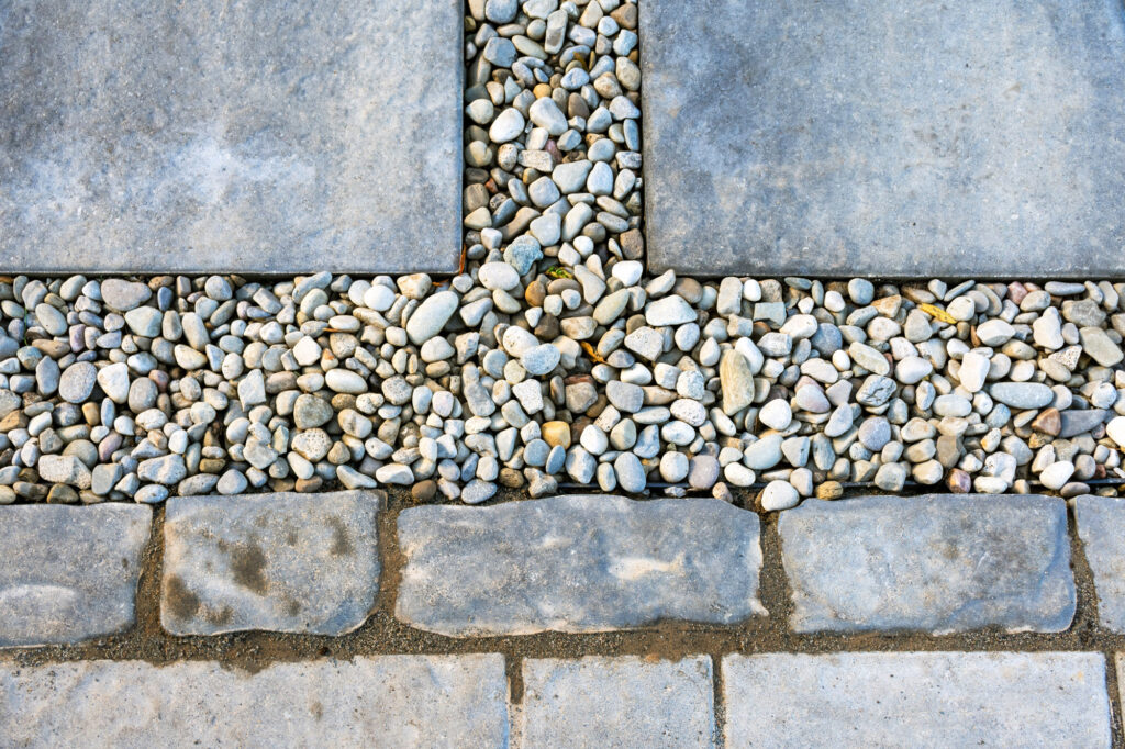 Concrete stepping stones surrounded by gray and white pea stones.